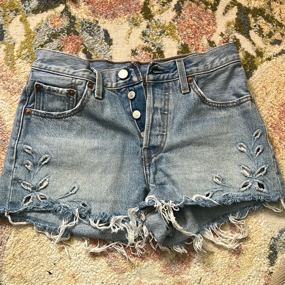 Like new distressed Levi’s with floral detailing on hem